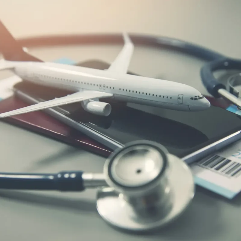 ostetoscopio junto a un pasaporte y un avión de juguete