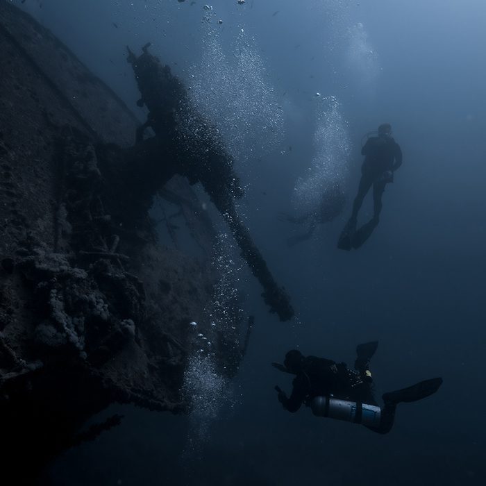 imagen de dos buceadores contemplando el cañon antiaereo situado en la proa del barco hundido SS Thistlegorm